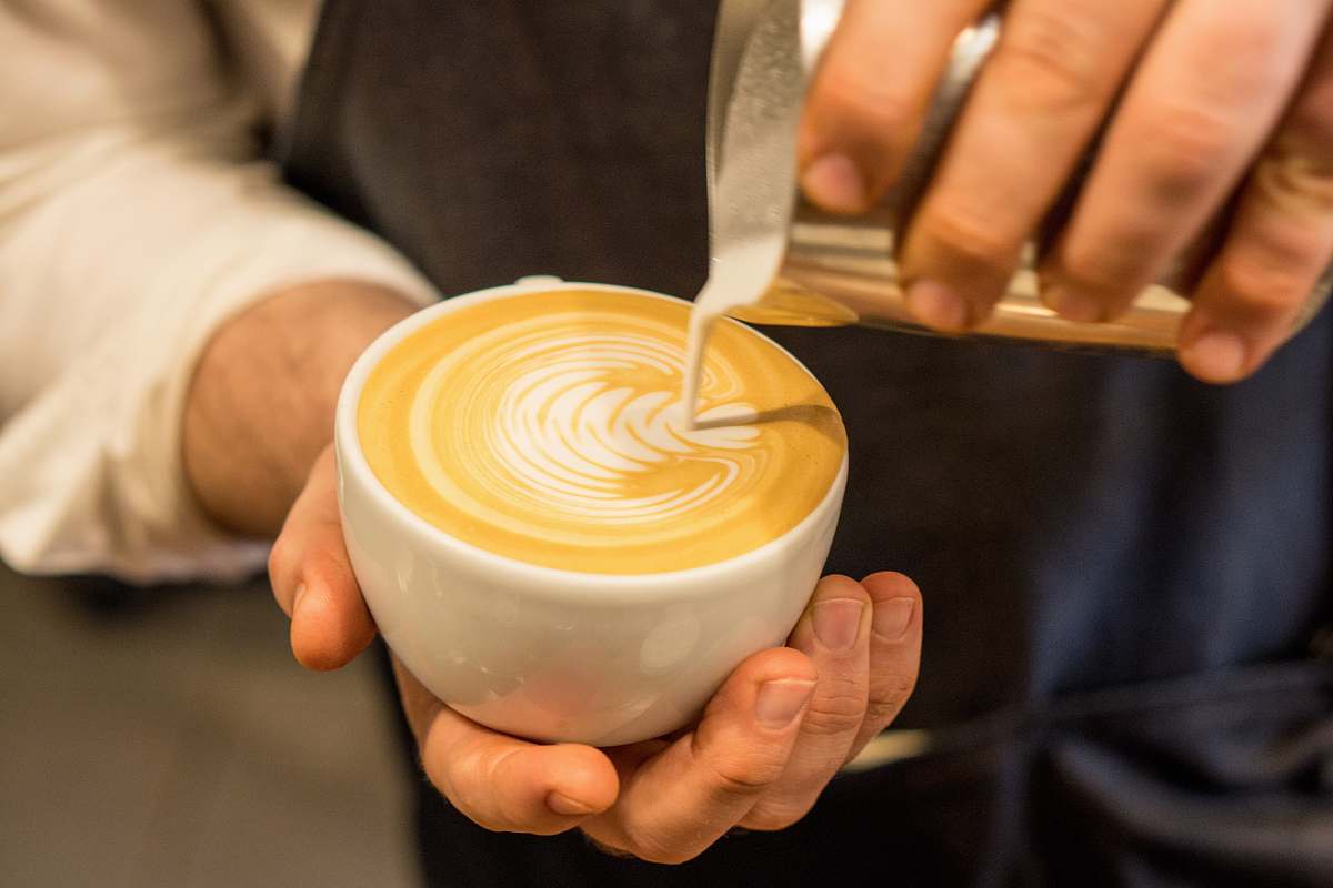 beverage person pouring cream on coffee drink